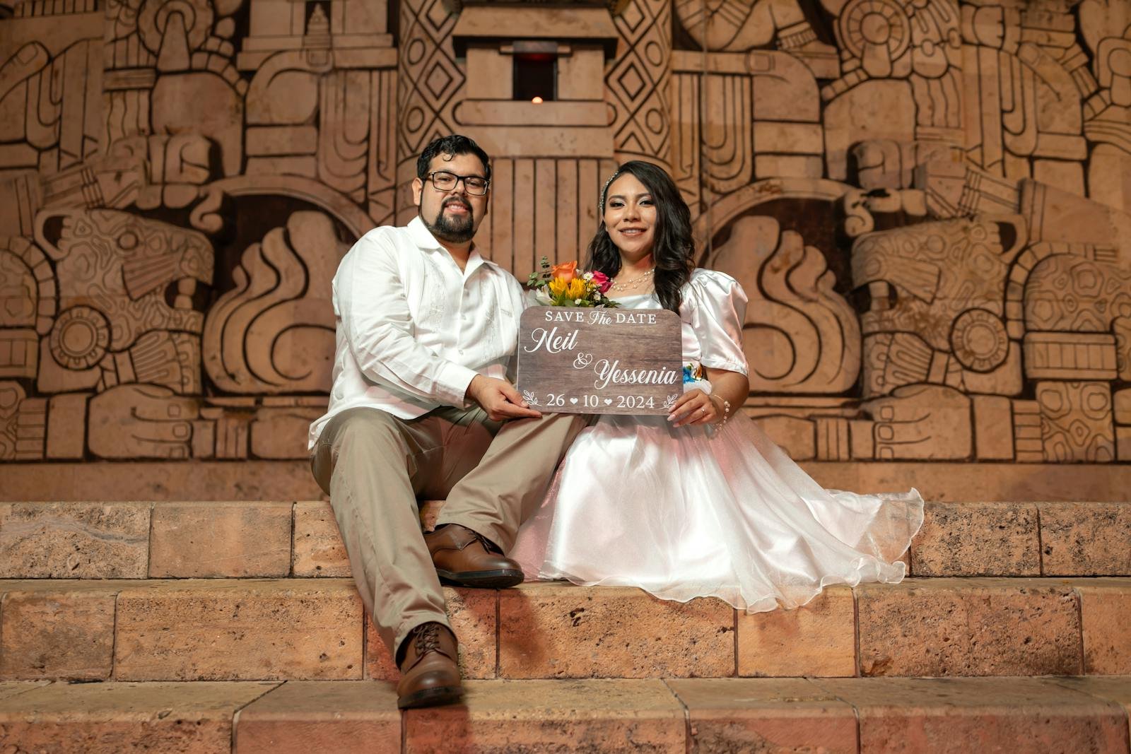 Engaged couple posing at a monument in Mérida, Yucatán, showcasing a traditional and romantic theme.