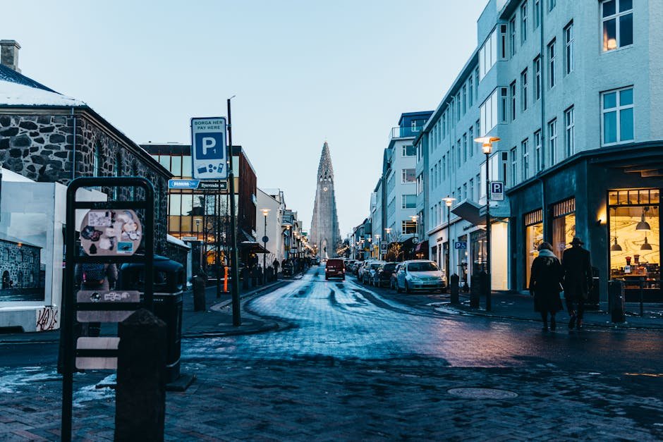 Rue de Reykjavik enneigee avec la silhouette de Hallgrimskirkja en arriere-plan