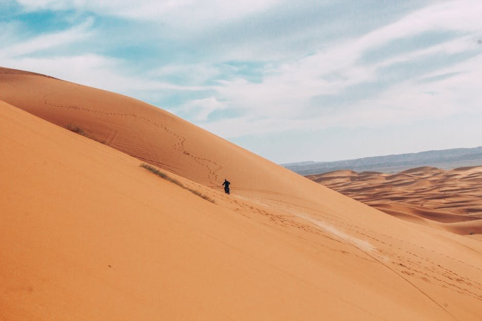 Voyageur marchant seul dans les dunes de Merzouga au Maroc