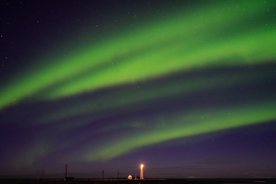 Aurore boreale verte illuminant le ciel nocturne au-dessus du phare de Grotta en Islande